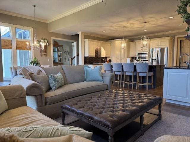 living room with an inviting chandelier, recessed lighting, crown molding, and dark wood-style flooring