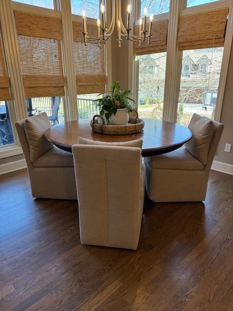 dining room featuring a chandelier, dark wood-type flooring, and baseboards