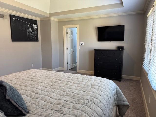 carpeted bedroom with a tray ceiling, baseboards, visible vents, and ornamental molding