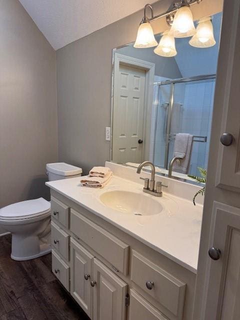 full bath featuring toilet, a stall shower, wood finished floors, vanity, and vaulted ceiling