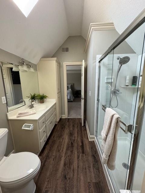 full bathroom featuring wood finished floors, visible vents, lofted ceiling, a shower stall, and toilet