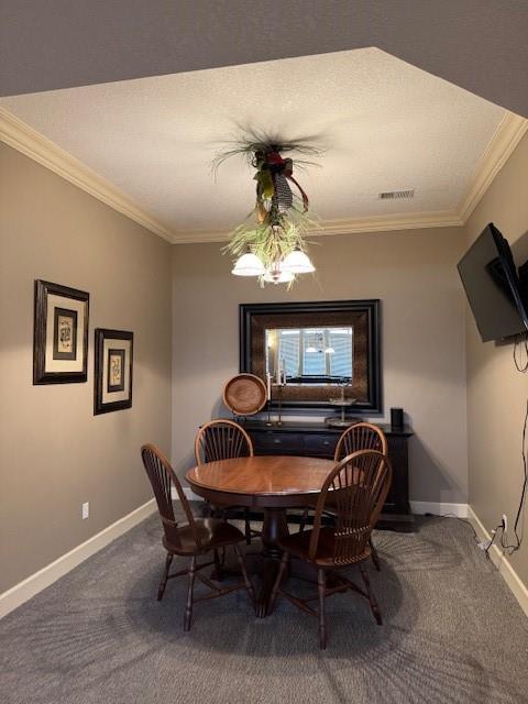 carpeted dining area featuring visible vents, baseboards, and crown molding