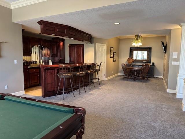 playroom featuring light colored carpet, baseboards, ornate columns, and ornamental molding