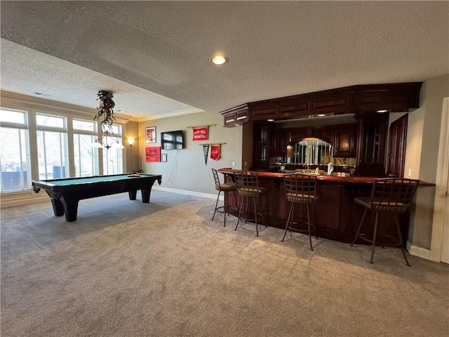 recreation room featuring baseboards, indoor bar, ornamental molding, light carpet, and a textured ceiling