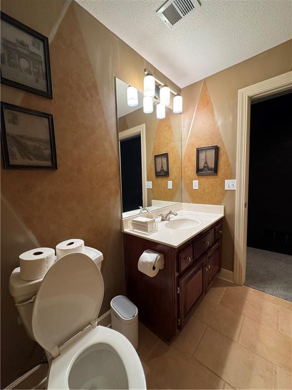 bathroom with vanity, toilet, visible vents, and a textured ceiling