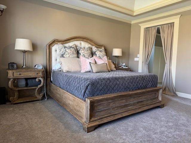 carpeted bedroom with crown molding and baseboards