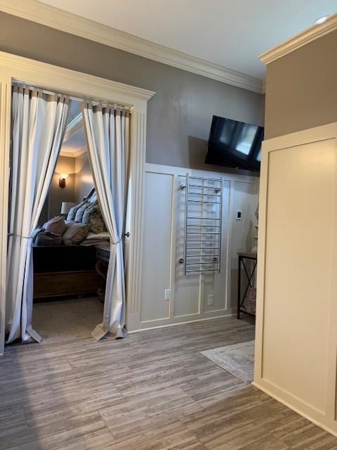 unfurnished bedroom featuring crown molding and wood finished floors