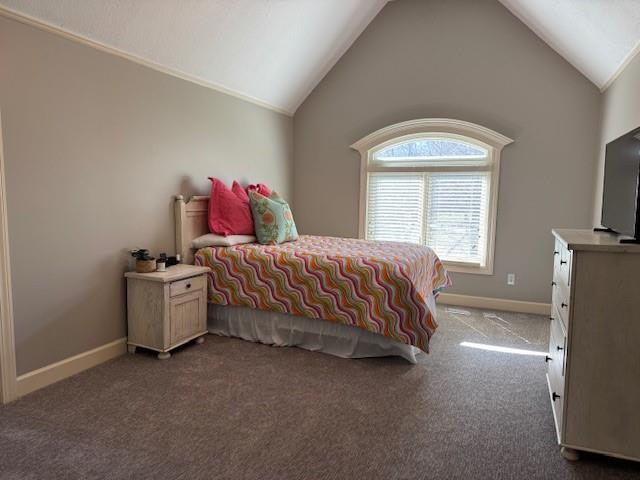 carpeted bedroom with vaulted ceiling and baseboards