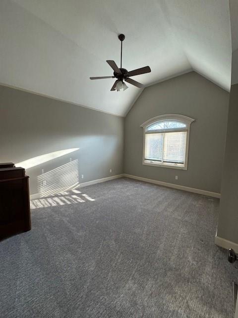 unfurnished bedroom featuring baseboards, lofted ceiling, and carpet