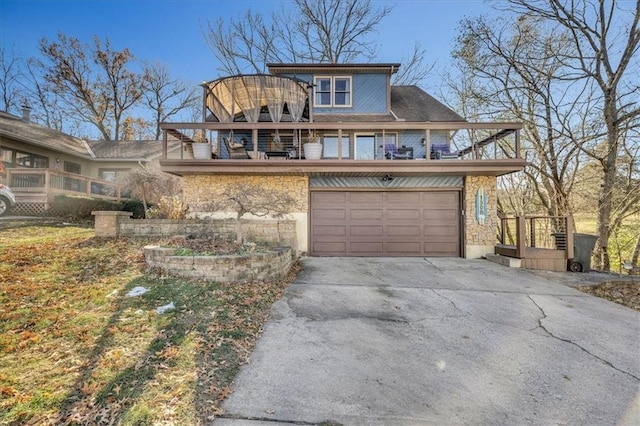 view of front of house with stone siding, an attached garage, concrete driveway, and a balcony