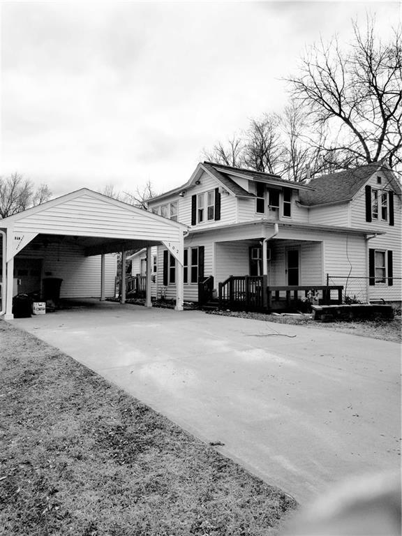 view of front of home featuring concrete driveway, a porch, and a carport