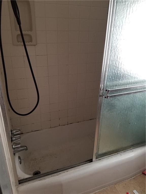 bathroom featuring tile patterned floors and combined bath / shower with glass door