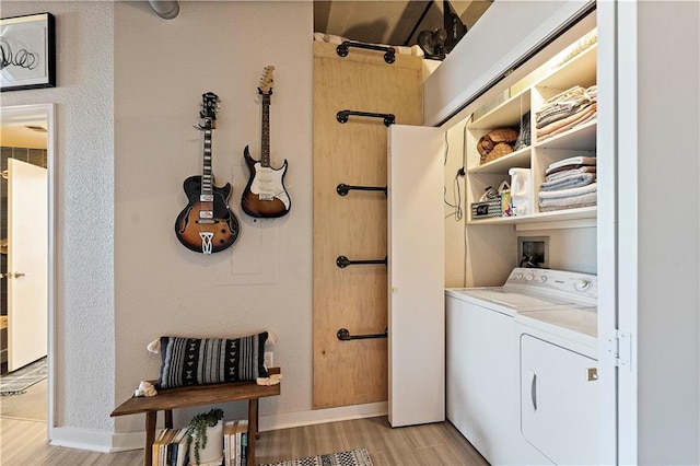 laundry area with light wood-type flooring, baseboards, independent washer and dryer, and laundry area