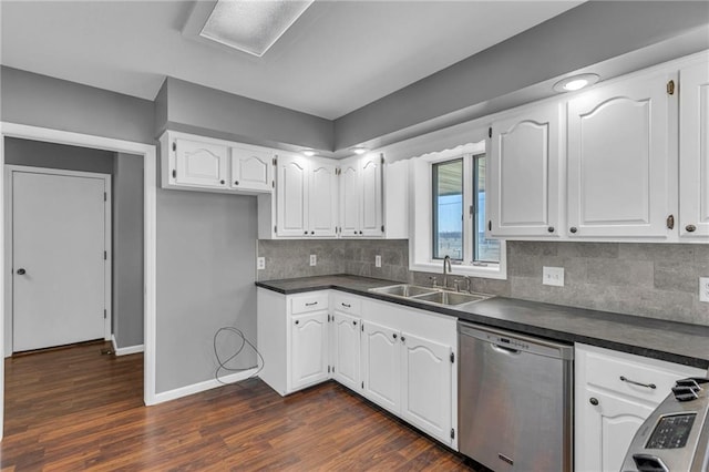 kitchen featuring baseboards, a sink, stainless steel appliances, white cabinets, and dark countertops