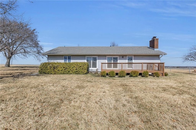 view of front of home featuring a deck, a front yard, and a chimney