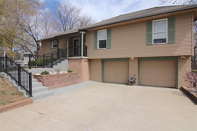 225 N Woodson Dr, Raymore, MO 64083 - view of front of home with an attached garage, driveway, and brick siding