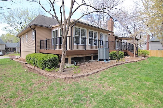 225 N Woodson Dr, Raymore, MO 64083 - rear view of property with a yard, central AC, a deck, and a chimney