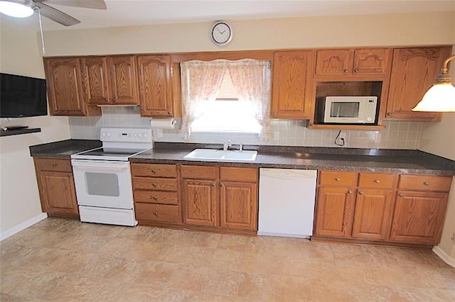 225 N Woodson Dr, Raymore, MO 64083 - kitchen featuring brown cabinets, a sink, and white appliances