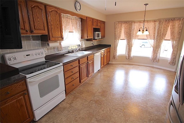 225 N Woodson Dr, Raymore, MO 64083 - kitchen featuring brown cabinetry, backsplash, dark countertops, and white appliances