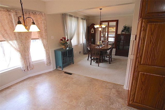225 N Woodson Dr, Raymore, MO 64083 - dining area featuring a chandelier, crown molding, baseboards, and visible vents