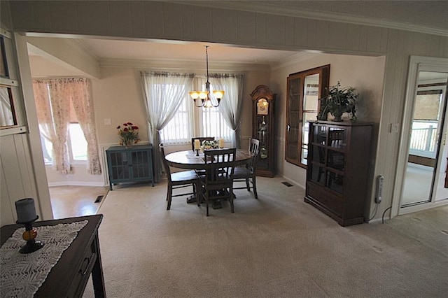 225 N Woodson Dr, Raymore, MO 64083 - dining area featuring a chandelier, crown molding, light carpet, and visible vents