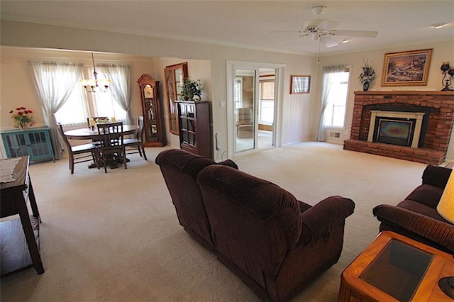 225 N Woodson Dr, Raymore, MO 64083 - carpeted living area featuring a fireplace, ceiling fan with notable chandelier, and ornamental molding