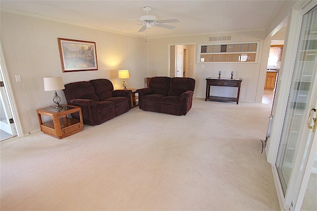 225 N Woodson Dr, Raymore, MO 64083 - carpeted living room featuring crown molding, visible vents, and a ceiling fan