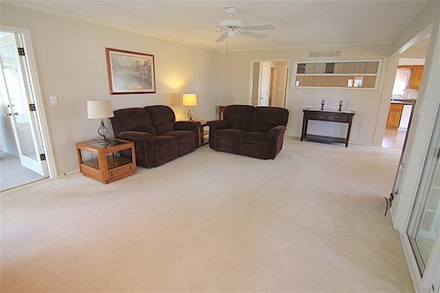 225 N Woodson Dr, Raymore, MO 64083 - living room featuring crown molding, carpet flooring, ceiling fan, and visible vents