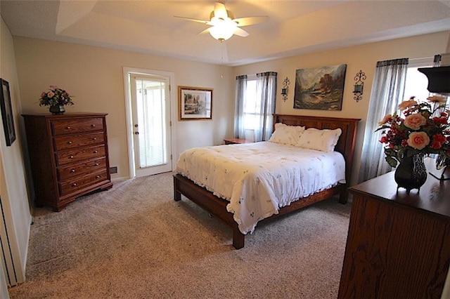 225 N Woodson Dr, Raymore, MO 64083 - bedroom with a tray ceiling, ceiling fan, and light colored carpet