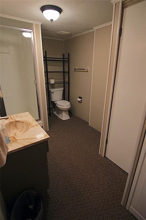 225 N Woodson Dr, Raymore, MO 64083 - full bathroom featuring a textured ceiling, vanity, ornamental molding, toilet, and walk in shower