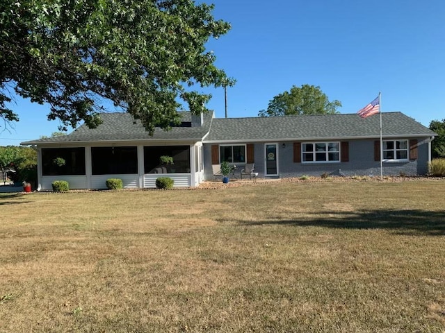 ranch-style home featuring a front lawn, a sunroom, and roof with shingles