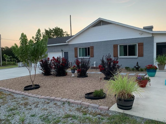 exterior space with brick siding, an attached garage, and concrete driveway