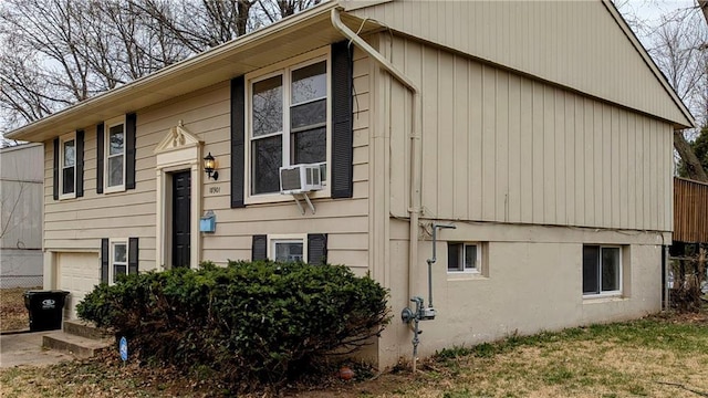 view of front of home with cooling unit and an attached garage