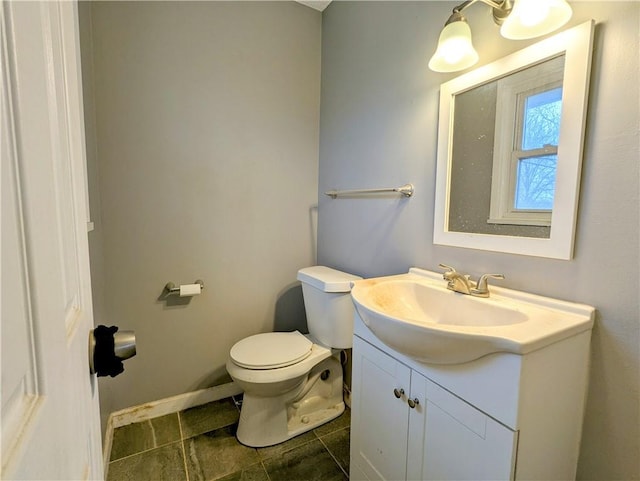 bathroom featuring baseboards, toilet, vanity, and tile patterned flooring