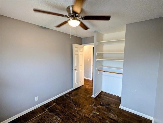 unfurnished bedroom featuring baseboards, a textured ceiling, wood finished floors, and a ceiling fan