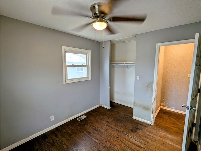 unfurnished bedroom featuring wood finished floors, visible vents, a closet, and baseboards