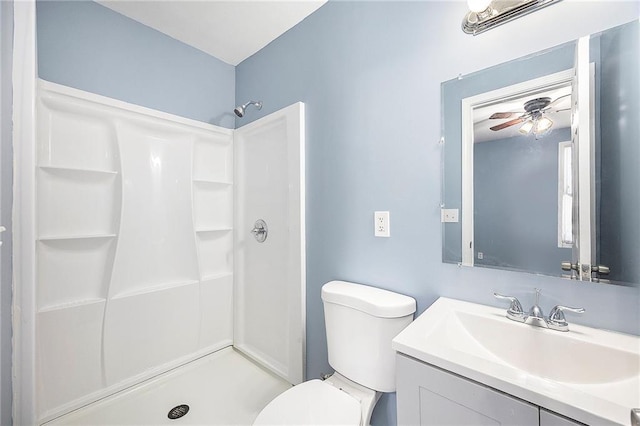 bathroom featuring a stall shower, toilet, vanity, and a ceiling fan