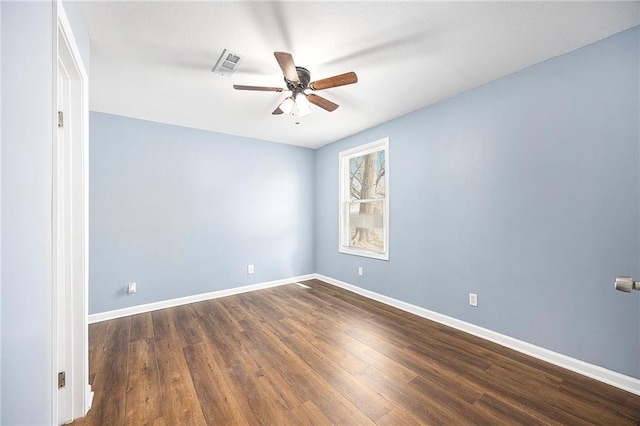 spare room with visible vents, baseboards, dark wood-type flooring, and ceiling fan