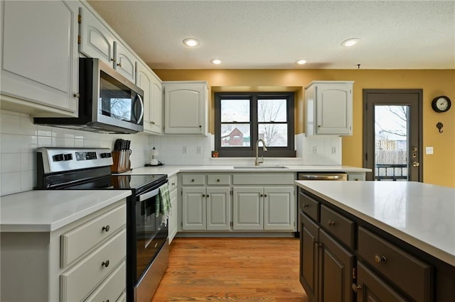 kitchen with light countertops, plenty of natural light, appliances with stainless steel finishes, and a sink