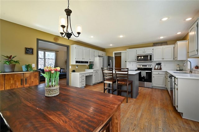 dining room featuring light wood finished floors, recessed lighting, and an inviting chandelier