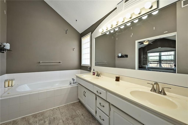 bathroom with vaulted ceiling, a healthy amount of sunlight, and a sink