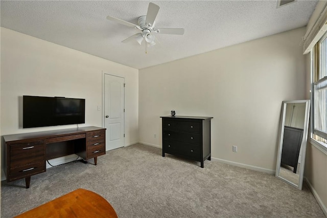 interior space with a ceiling fan, baseboards, carpet floors, and a textured ceiling