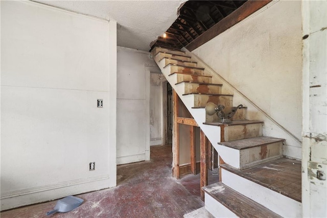 stairs featuring a textured ceiling