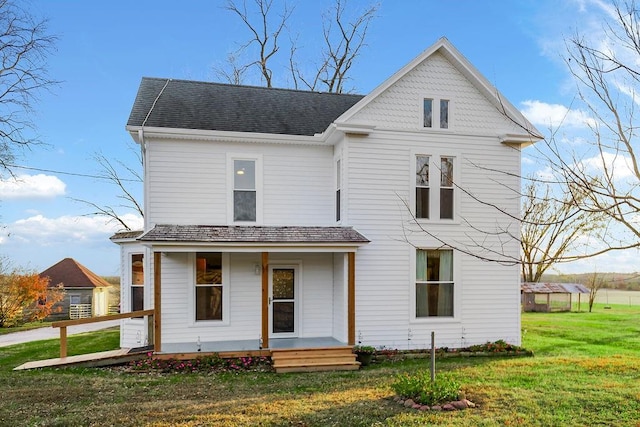 view of front facade featuring a front yard, covered porch, and roof with shingles