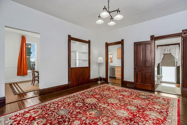 interior space with baseboards, an inviting chandelier, and hardwood / wood-style floors