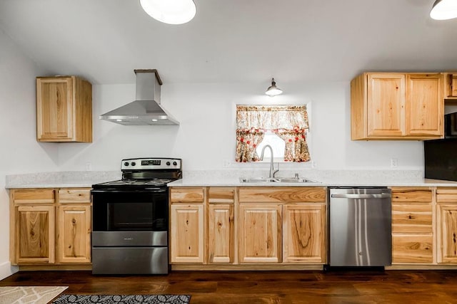 kitchen with wall chimney range hood, light brown cabinetry, light countertops, stainless steel appliances, and a sink