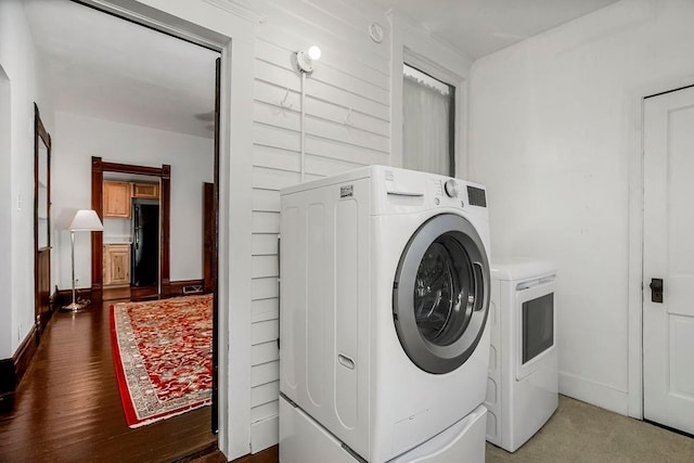 laundry area with washer and dryer, laundry area, wood finished floors, and baseboards