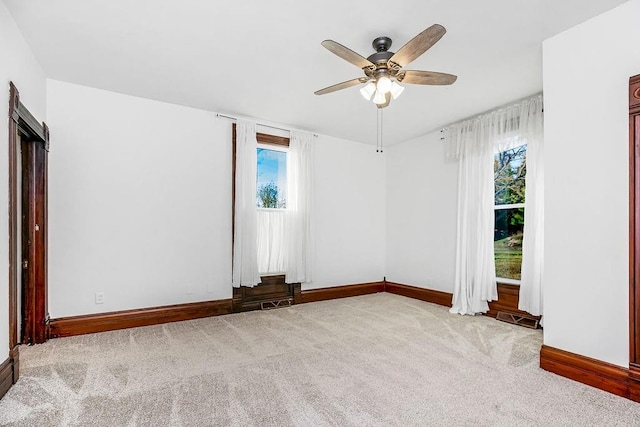 unfurnished room featuring carpet flooring, plenty of natural light, baseboards, and ceiling fan