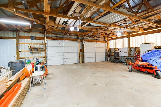 garage featuring a garage door opener and metal wall