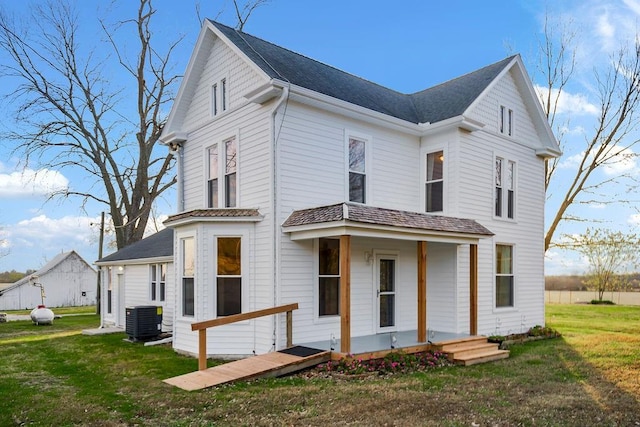 view of front of home with a front lawn and central AC